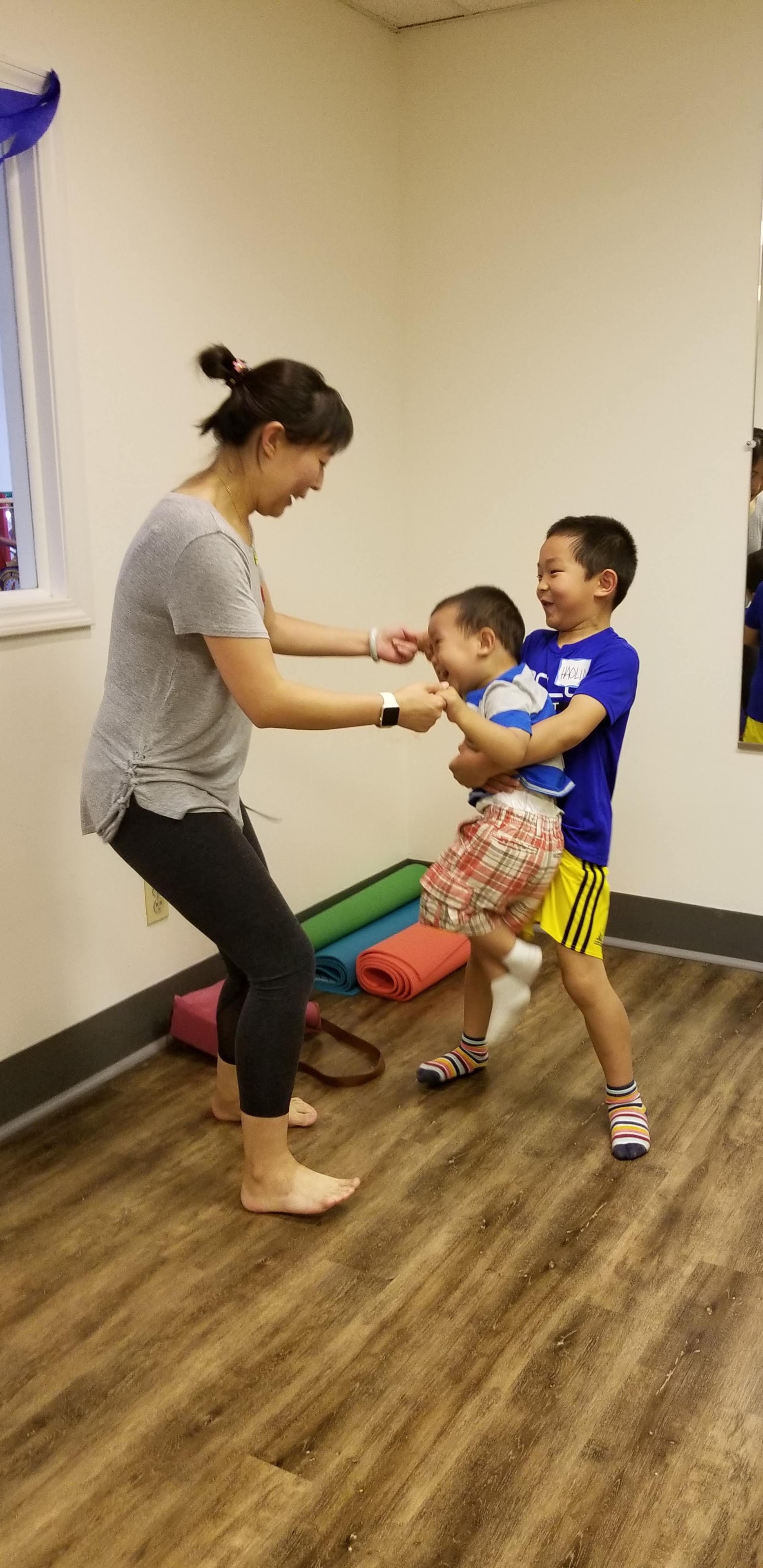 A mom dancing with her two boys during a Zumbini class